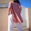 Mujer de espalda vistiendo cárdigan largo rosa.