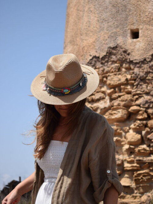 Mujer vistiendo Sombrero de mujer beige estilo Boho con ala ancho con faro de fondo