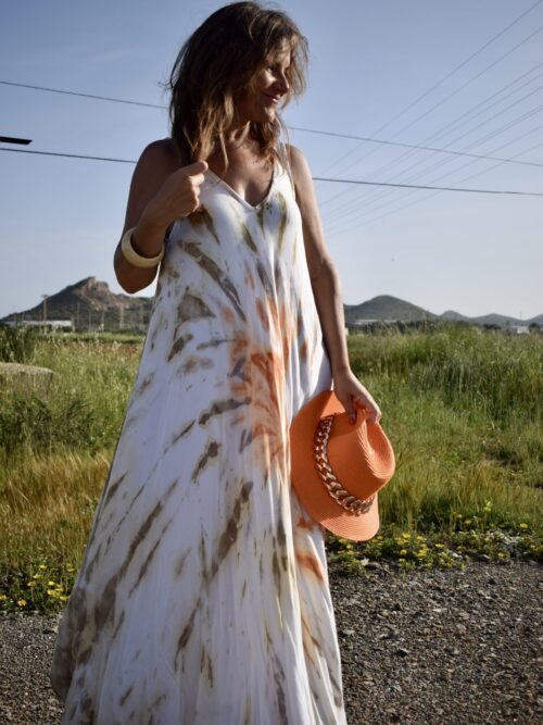 Mujer vistiendo vestido largo. tie dye en tonos beige naranja y tostado.
